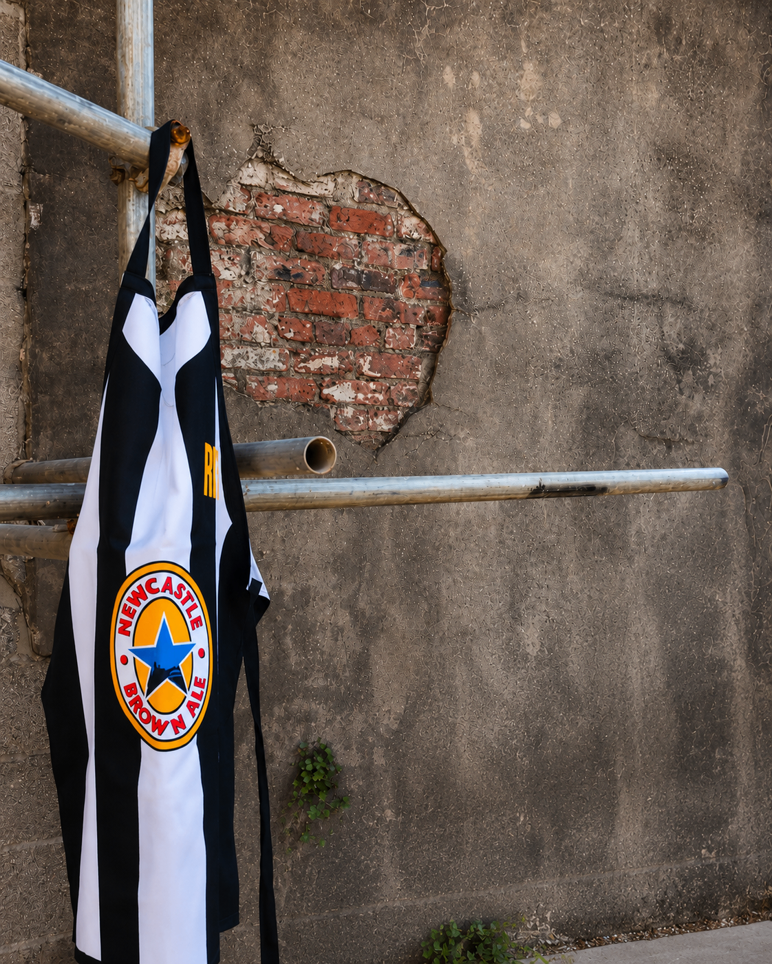 Black and white striped apron against a textured brick wall